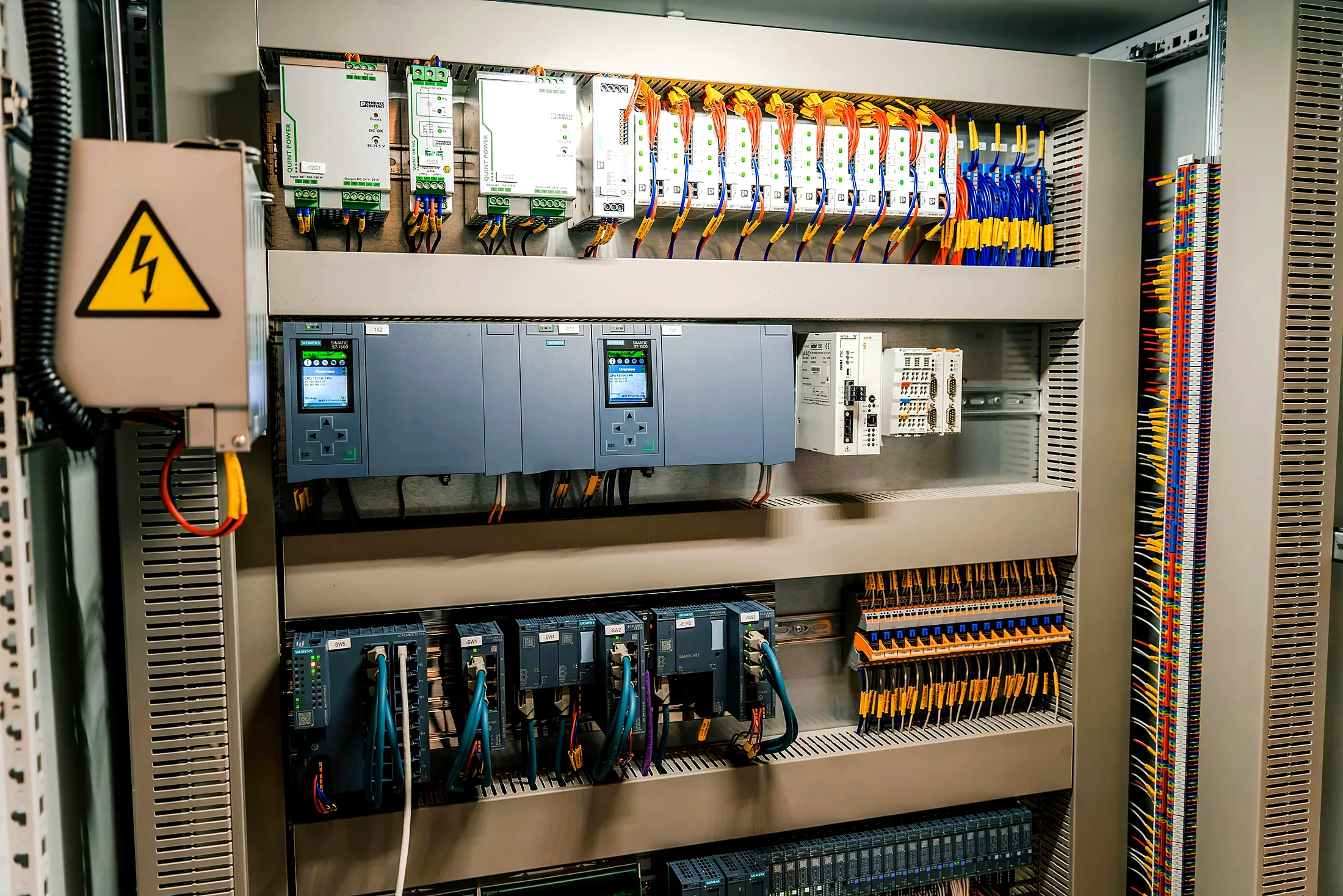 Electrical control cabinet with modules, labelled wiring and terminal blocks.